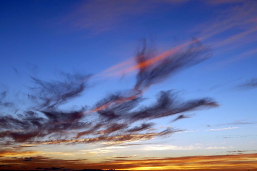 Dark clouds streaked with red above a blue and golden sunset sky.